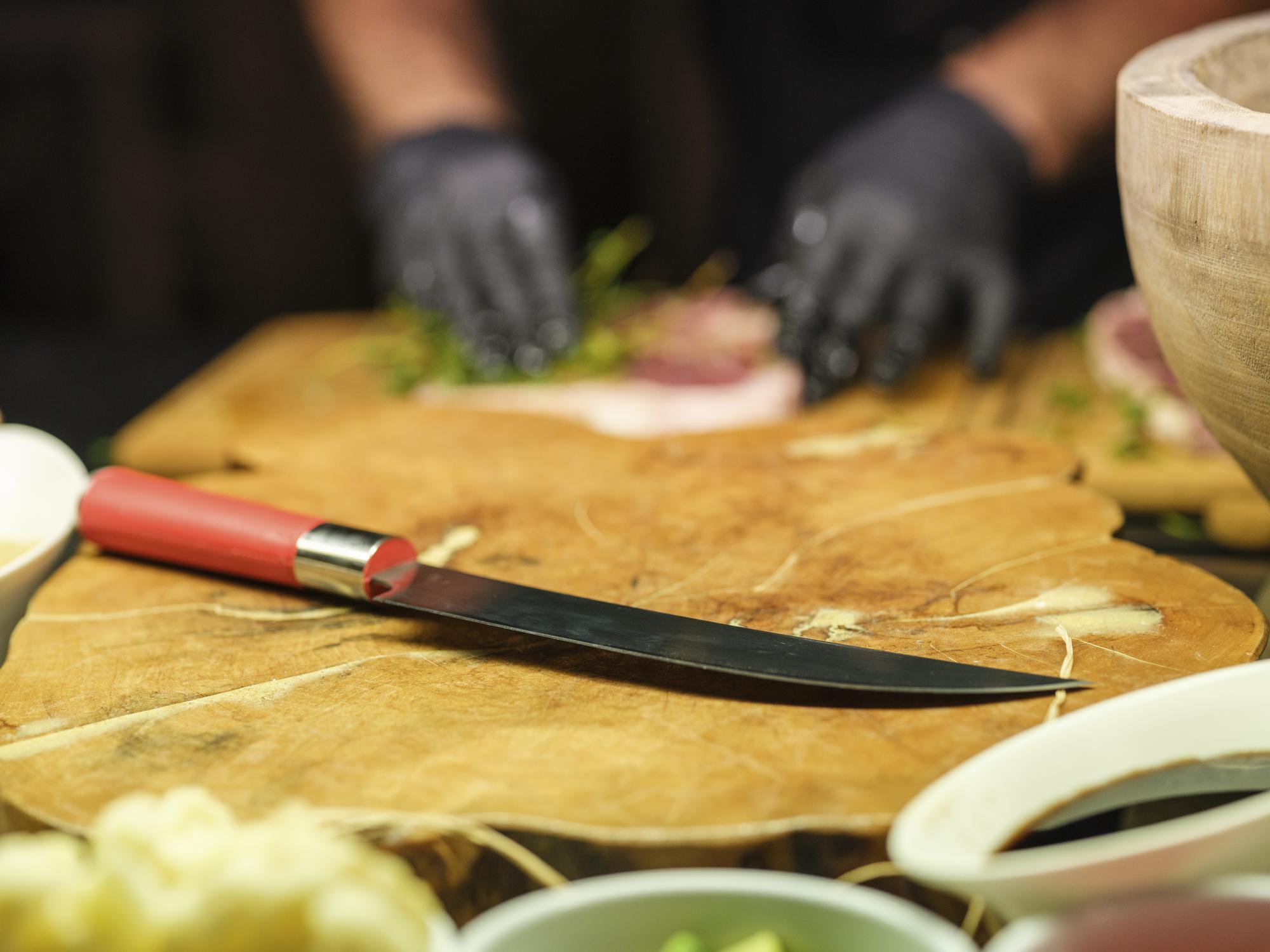 Chef demonstrating knife technique to small group